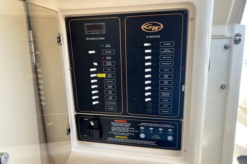 Slide: The Image of Electrical panel of a 2017 Grady-White Marlin 300 boat, showing AC and DC switches. - 13