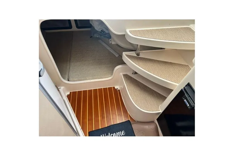 Slide: The Image of Interior view of 2017 Grady-White Marlin 300 boat with carpeted stairs and welcome mat. - 14