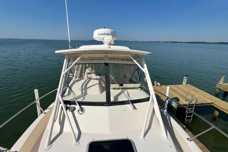 Slide: The Image of 2017 Grady-White Marlin 300 boat docked on calm water with Garmin radar. - 17