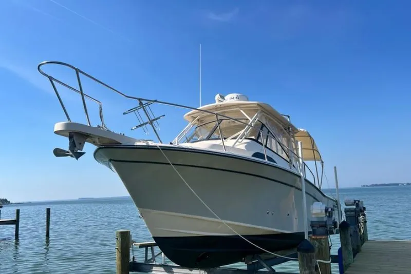 Slide: The Image of 2017 Grady-White Marlin 300 boat docked on a sunny day by the water. - 2