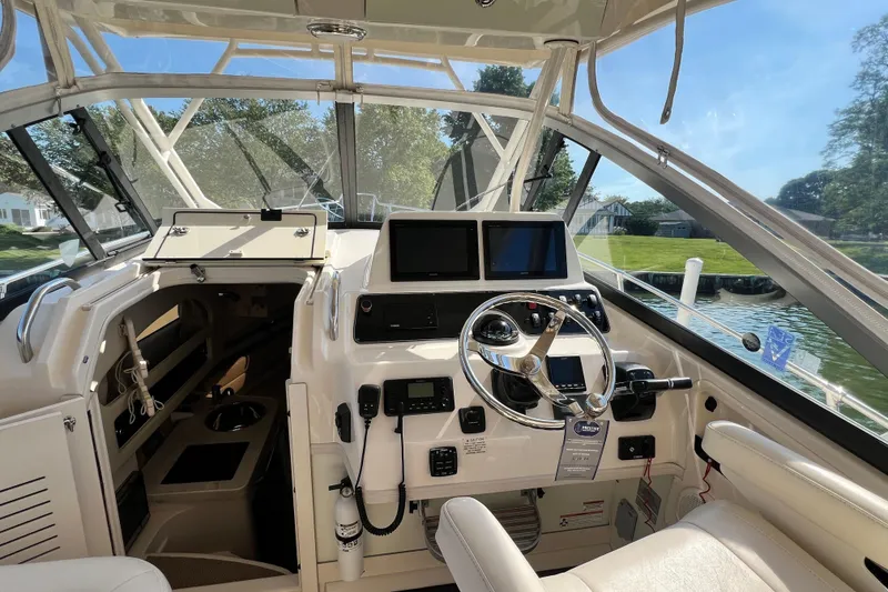 Slide: The Image of 2017 Grady-White Marlin 300 boat cockpit with steering wheel and navigation screens. - 22