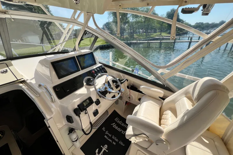 Slide: The Image of 2017 Grady-White Marlin 300 helm with dual screens, steering wheel, and comfortable seating. - 23