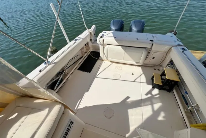 Slide: The Image of 2017 Grady-White Marlin 300 boat deck with twin engines, docked on calm water. - 25
