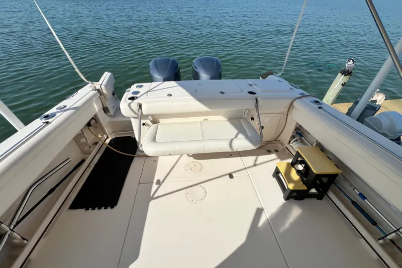 Slide: The Image of 2017 Grady-White Marlin 300 boat deck with twin engines, docked on calm water. - 6