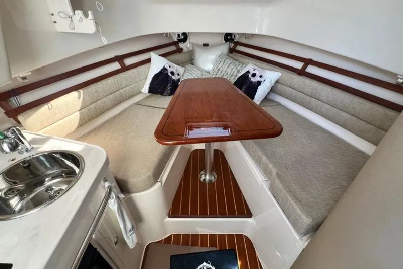 Slide: The Image of 2017 Grady-White Marlin 300 cabin interior with seating, table, and sink. - 9