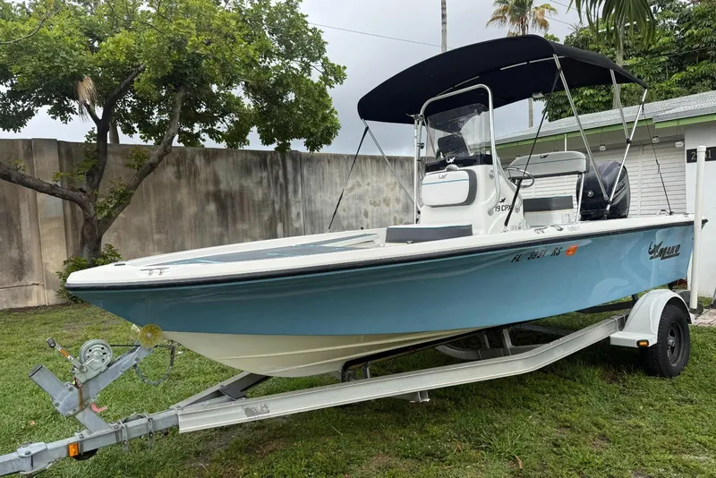 The Image of 2015 Mako 19 CPX boat on trailer with canopy, parked on grass. - 0