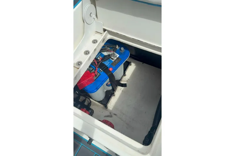 Slide: The Image of Battery compartment of a 2015 Mako 19 CPX boat, featuring a blue marine battery. - 10