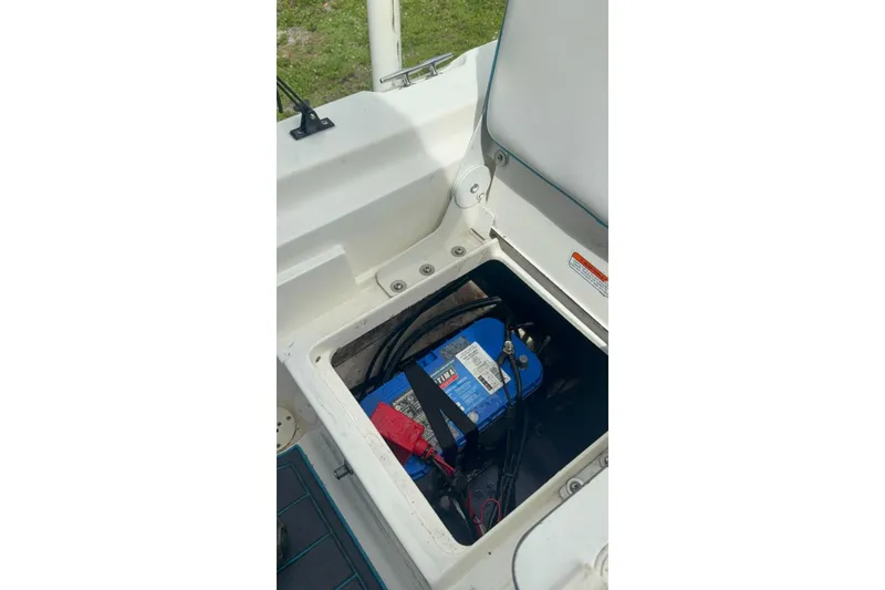 Slide: The Image of Battery compartment of a 2015 Mako 19 CPX boat, showing a blue marine battery. - 11