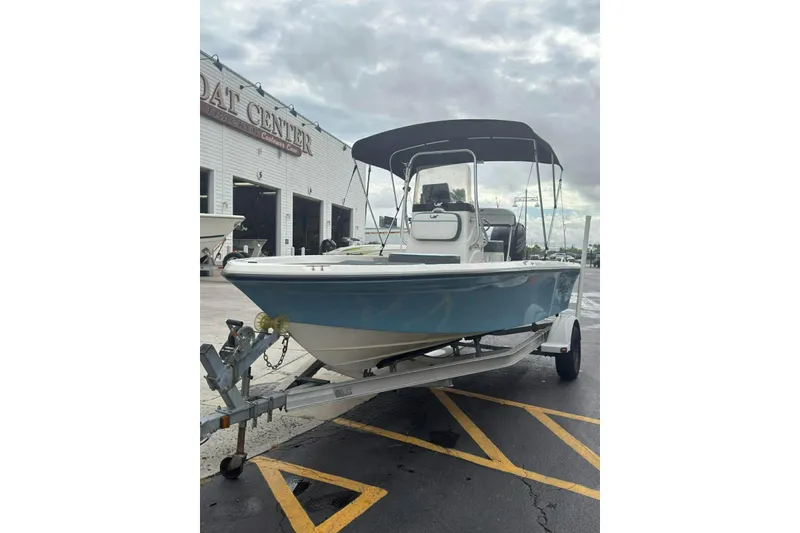 Slide: The Image of 2015 Mako 19 CPX boat on trailer at dealership, under cloudy sky. - 5