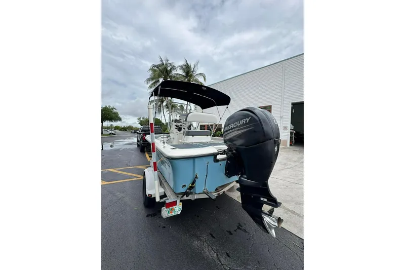 Slide: The Image of 2015 Mako 19 CPX boat with Mercury outboard motor on trailer, parked outdoors. - 6