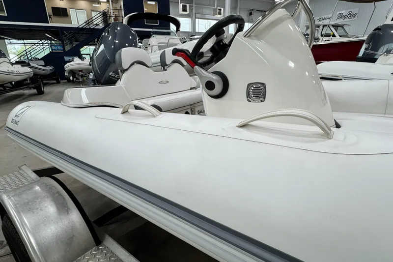 Slide: The Image of 2021 Zodiac Yachtline 440 inflatable boat in showroom, featuring sleek design and modern controls. - 13