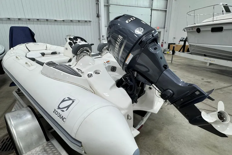 Slide: The Image of 2021 Zodiac Yachtline 440 inflatable boat with Yamaha 60 outboard motor in a garage. - 2