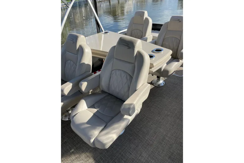 Slide: The Image of Luxurious seating on a 2015 Bennington 2575 QSD pontoon boat, featuring plush, beige upholstery. - 12