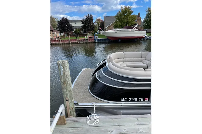 Slide: The Image of 2015 Bennington 2575 QSD pontoon boat docked on a calm waterfront. - 17