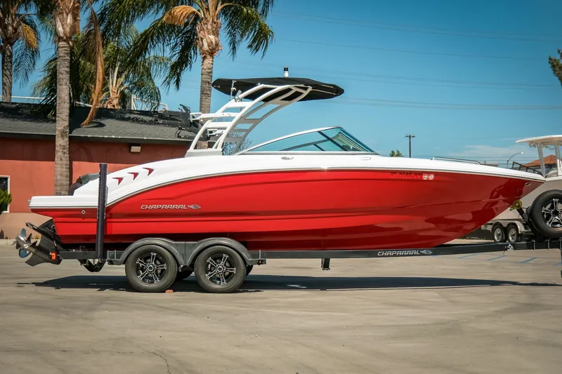 The Image of 2021 Chaparral 23 SSi boat in vibrant red on a trailer, parked outdoors. - 0