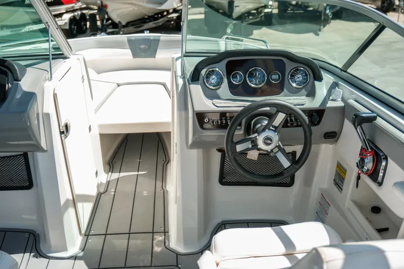 Slide: The Image of 2021 Chaparral 23 SSi boat interior with steering wheel and dashboard controls. - 10