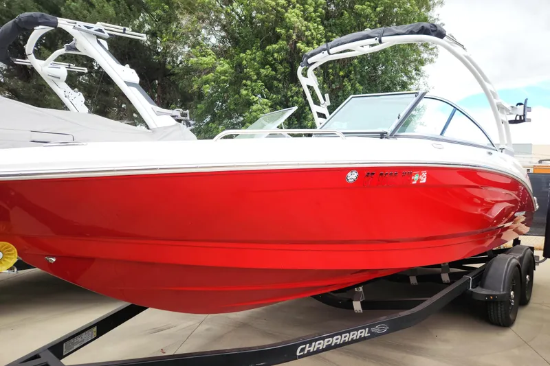 Slide: The Image of 2021 Chaparral 23 SSi boat in vibrant red on trailer, outdoors. - 2