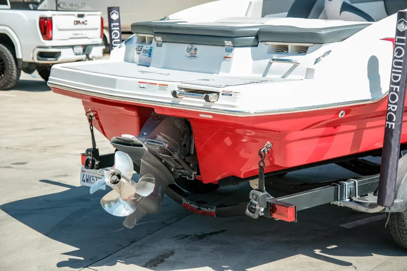 Slide: The Image of 2021 Chaparral 23 SSi boat with red hull and visible propeller on trailer. - 8