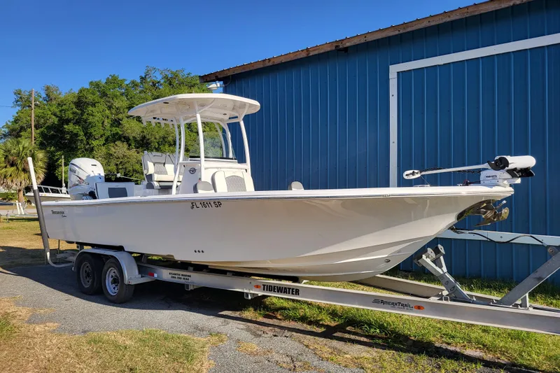 The Image of 2020 Tidewater 2700 Carolina Bay boat on trailer, parked beside blue building. - 0