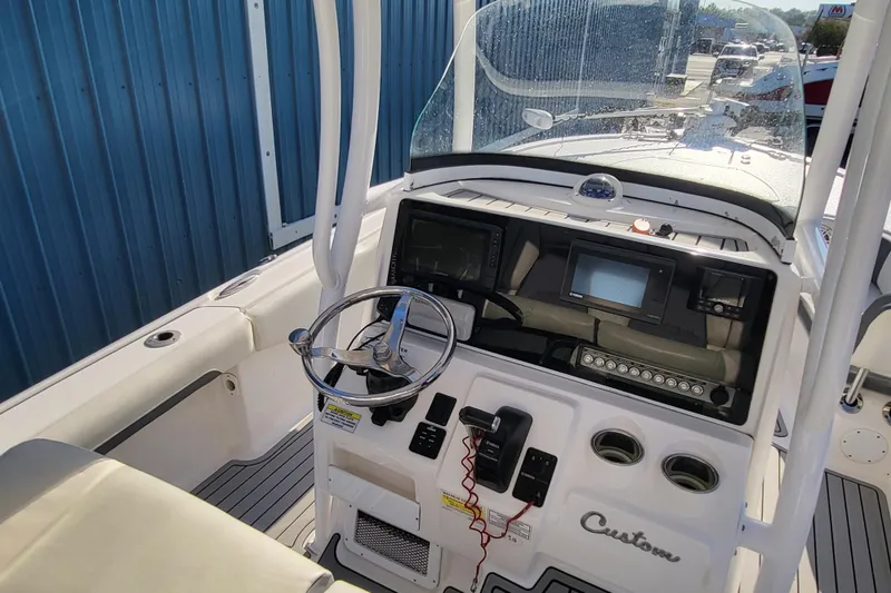 Slide: The Image of 2020 Tidewater 2700 Carolina Bay boat dashboard with steering wheel and navigation controls. - 5
