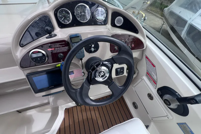 Slide: The Image of 2006 Sea Ray Sundancer 260 helm with steering wheel, gauges, and navigation equipment. - 10