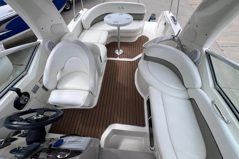 Slide: The Image of 2006 Sea Ray Sundancer 260 interior with white seating and wood flooring. - 12