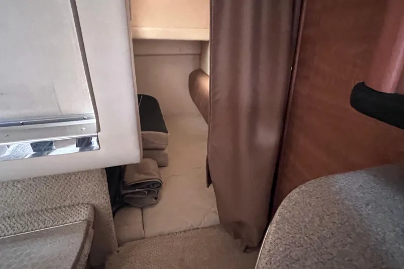 Slide: The Image of Interior cabin view of a 2006 Sea Ray Sundancer 260, featuring cozy sleeping area. - 17