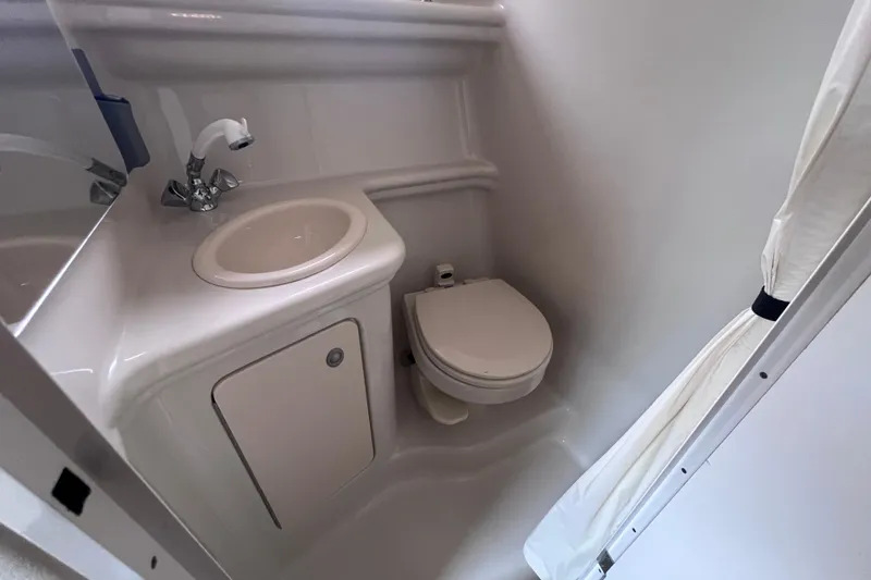 Slide: The Image of Compact bathroom in 2006 Sea Ray Sundancer 260 boat, featuring sink and toilet. - 18
