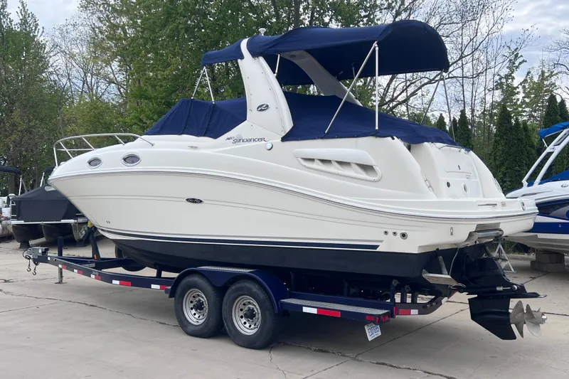 Slide: The Image of 2006 Sea Ray Sundancer 260 boat on trailer, featuring sleek design and blue canopy. - 2