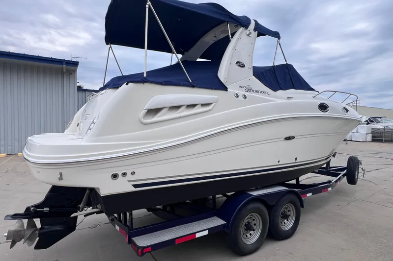 Slide: The Image of 2006 Sea Ray Sundancer 260 boat on trailer, featuring sleek design and blue canopy. - 3