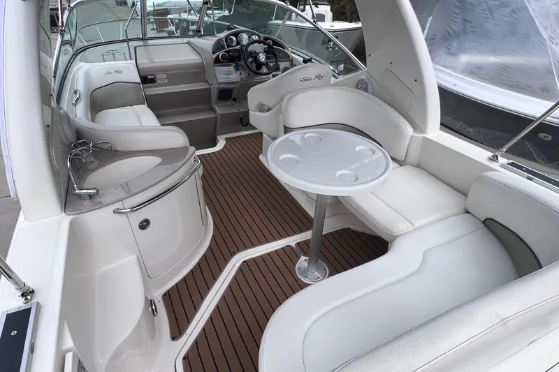 Slide: The Image of 2006 Sea Ray Sundancer 260 interior with seating, table, and helm, featuring sleek design. - 5
