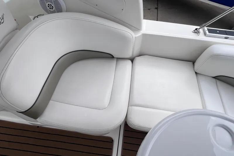 Slide: The Image of 2006 Sea Ray Sundancer 260 interior seating with white upholstery and wooden flooring. - 6