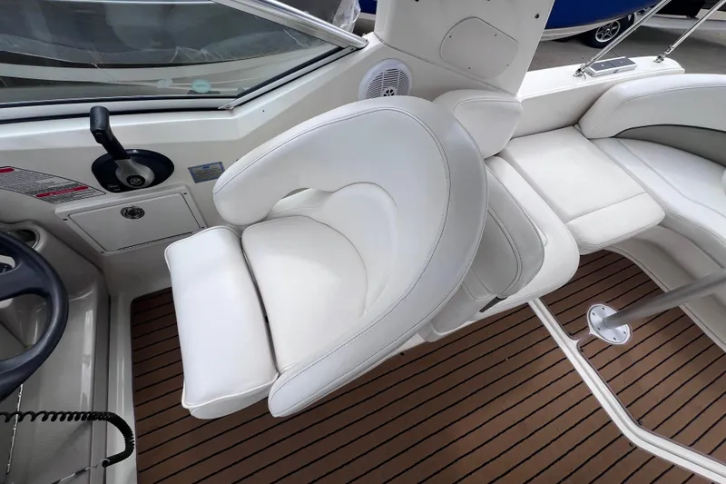 Slide: The Image of 2006 Sea Ray Sundancer 260 interior with white seating and wood-patterned flooring. - 9