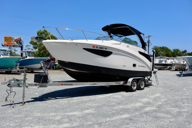 Slide: The Image of 2023 Regal 26 XO boat on trailer in sunny outdoor setting. - 1