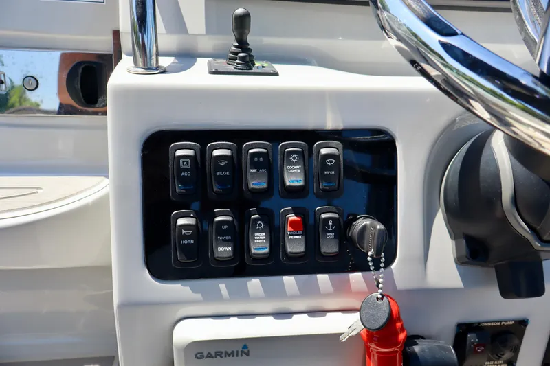 Slide: The Image of Control panel of 2023 Regal 26 XO boat with various switches and Garmin device. - 19