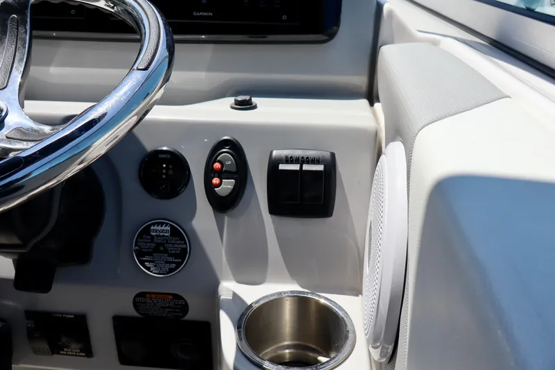 Slide: The Image of 2023 Regal 26 XO boat dashboard with steering wheel, controls, and cup holder. - 21