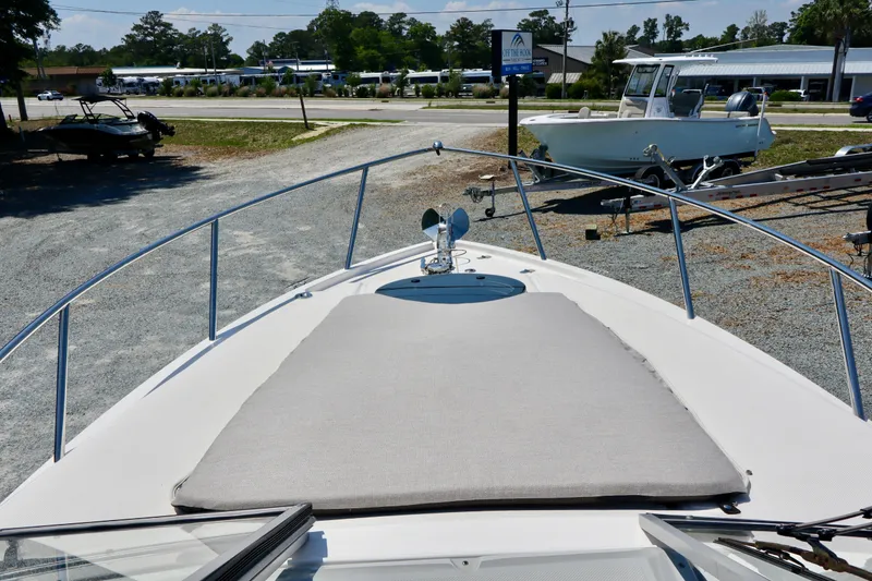 Slide: The Image of 2023 Regal 26 XO boat deck with sunpad, parked in a marina. - 26