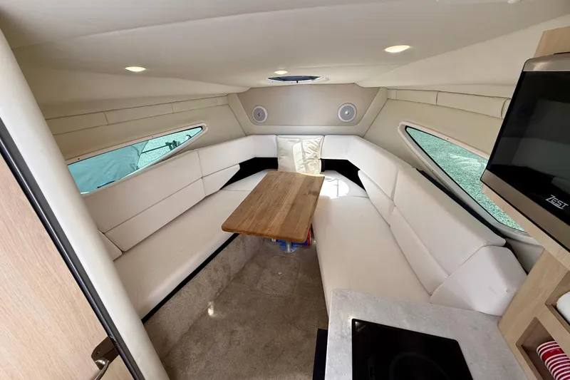 Slide: The Image of Interior of 2023 Regal 26 XO boat with white seating and wooden table. - 29