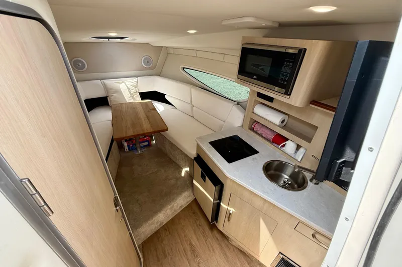 Slide: The Image of 2023 Regal 26 XO boat interior with kitchenette and seating area. - 30