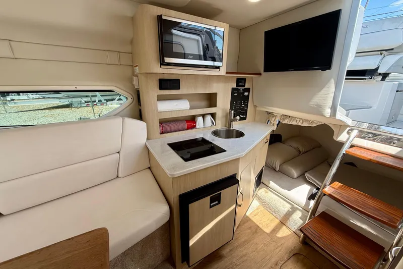 Slide: The Image of Interior of 2023 Regal 26 XO boat featuring kitchenette and seating area. - 31