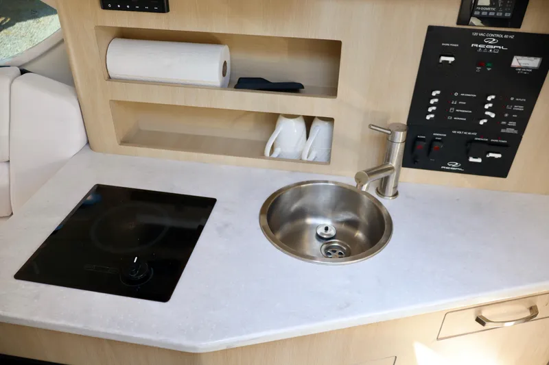 Slide: The Image of Compact kitchen area in 2023 Regal 26 XO boat with sink and stove. - 32