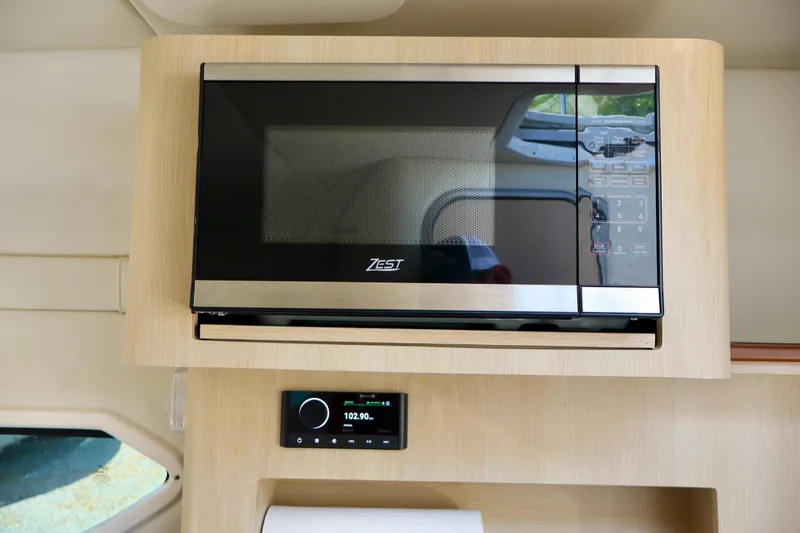 Slide: The Image of Microwave and control panel inside 2023 Regal 26 XO boat cabin. - 33