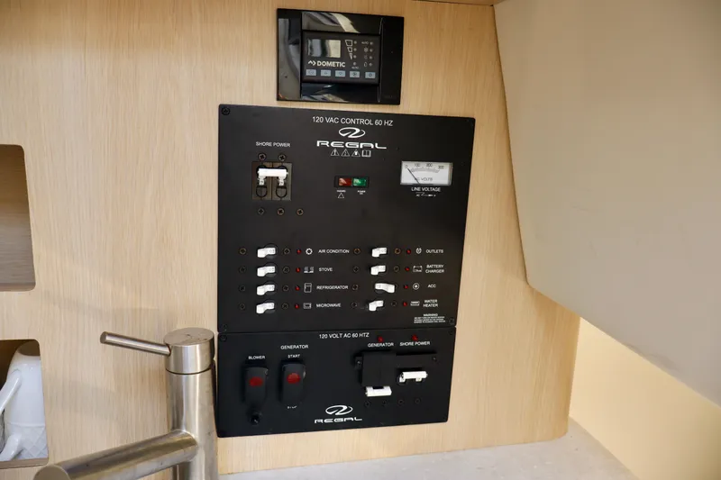 Slide: The Image of 2023 Regal 26 XO boat control panel with switches and voltage meter. - 34