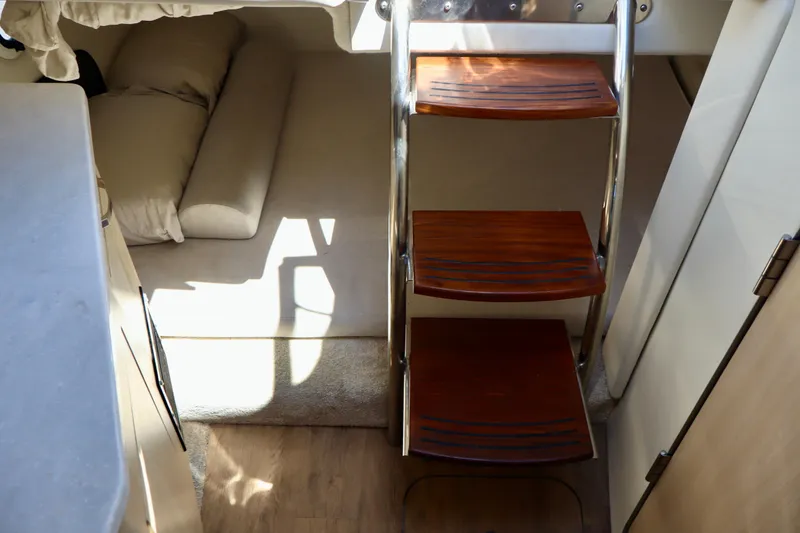 Slide: The Image of Interior of 2023 Regal 26 XO boat featuring wooden steps and cozy sleeping area. - 35