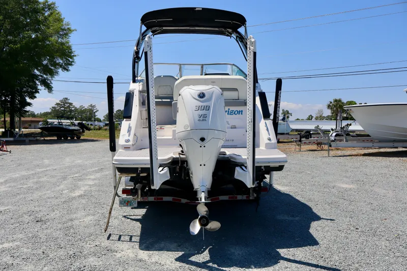 Slide: The Image of 2023 Regal 26 XO boat with powerful outboard motor, parked on gravel lot. - 5