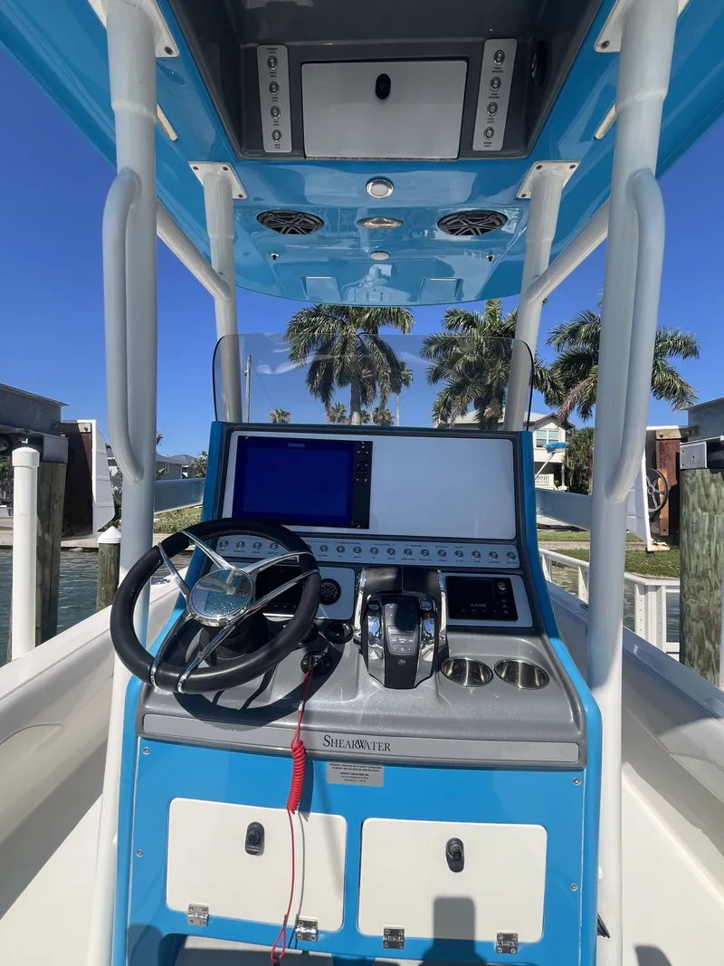 Slide: The Image of 2020 ShearWater Carolina boat console with blue trim and steering wheel. - 20