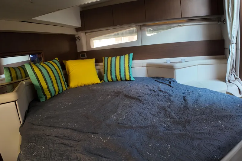 Slide: The Image of Luxurious cabin interior of 2015 Sea Ray 370 Venture with colorful pillows and cozy bedding. - 11
