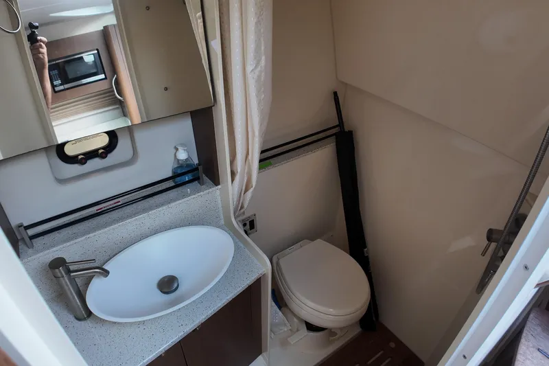Slide: The Image of 2015 Sea Ray 370 Venture bathroom with sink, toilet, and mirror. - 7