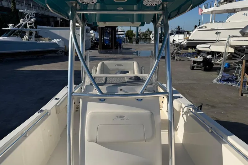 Slide: The Image of 2018 Cobia 220 Center Console boat at marina, showcasing sleek design and spacious deck. - 11