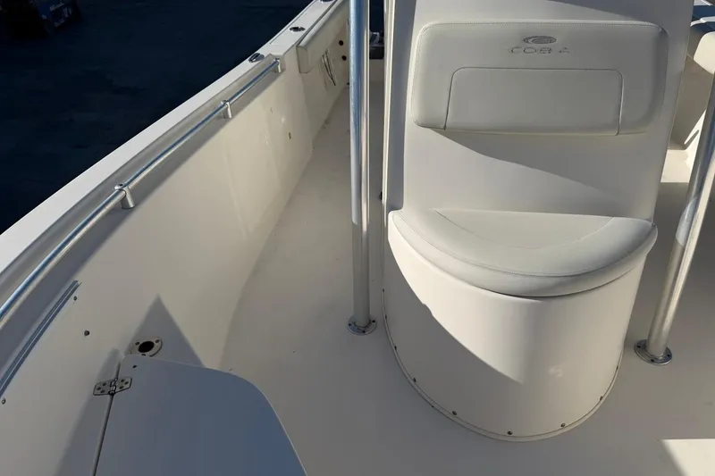 Slide: The Image of 2018 Cobia 220 Center Console boat interior with white seating and stainless steel railings. - 12